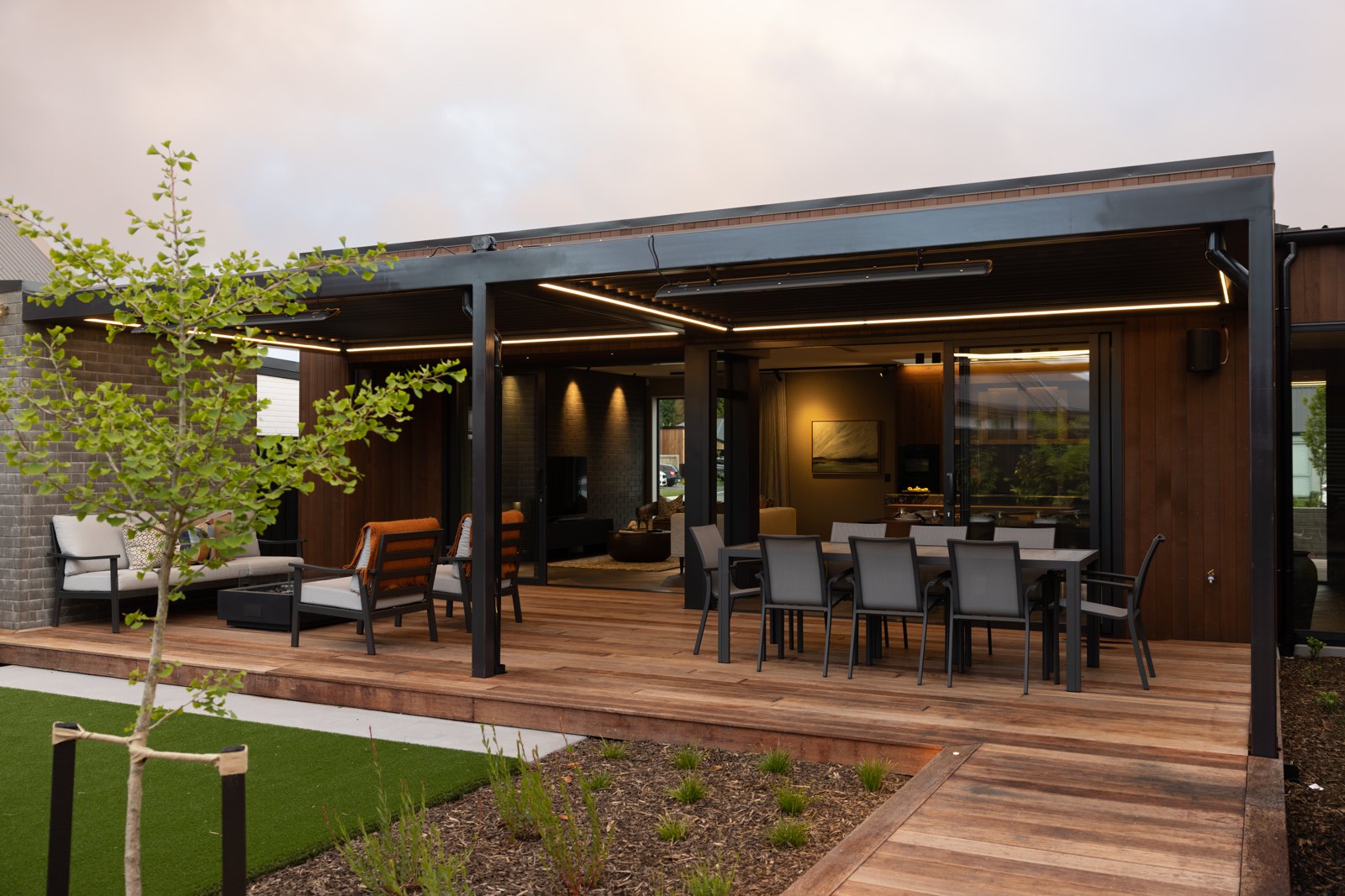 Steel pergola over an outdoor dining and lounge deck at a Christchurch home, by ARC Design Studio