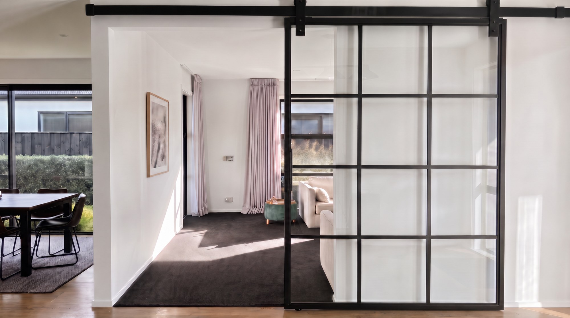 Black steel Crittall-style sliding glass door in a modern New Zealand home, by ARC Design Studio